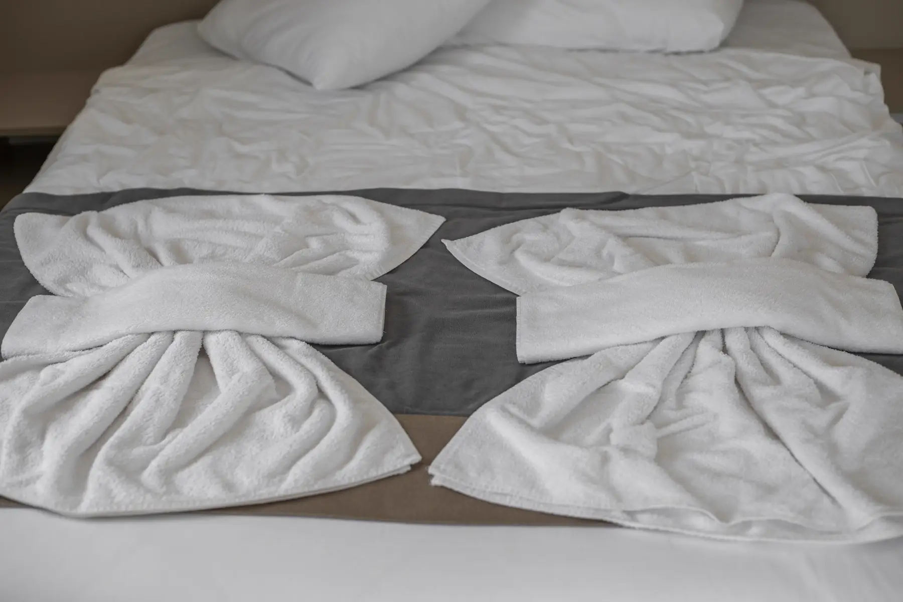 Cama hecha con toallas limpias, lista para el próximo huésped